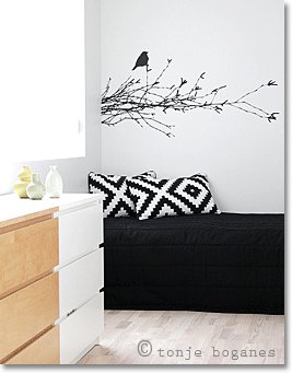 Scandinavian interiors: black sofa with black-and-white cushions and a black wall decal